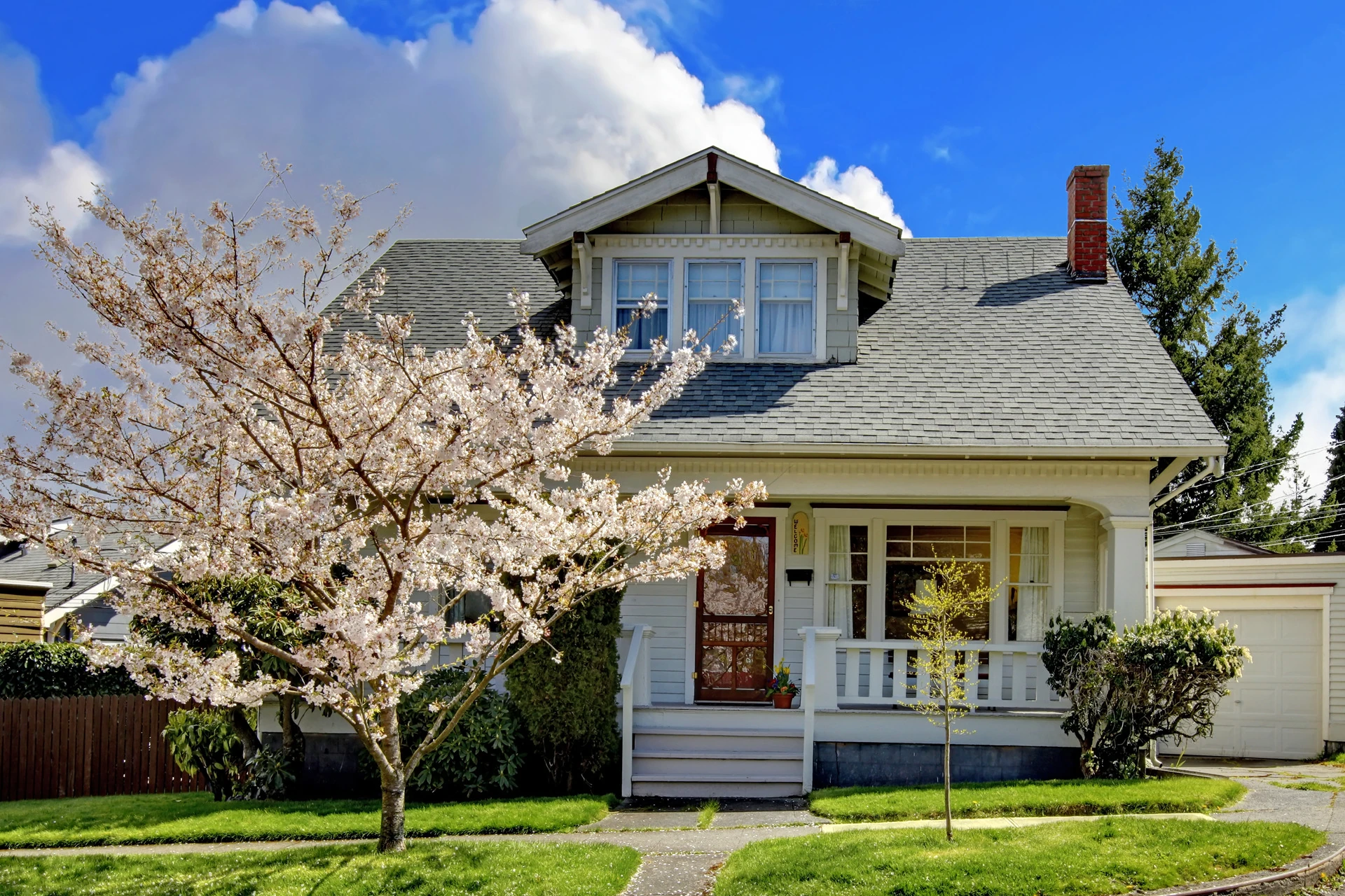 Quaint old house with a cherry blossom tree in front.
