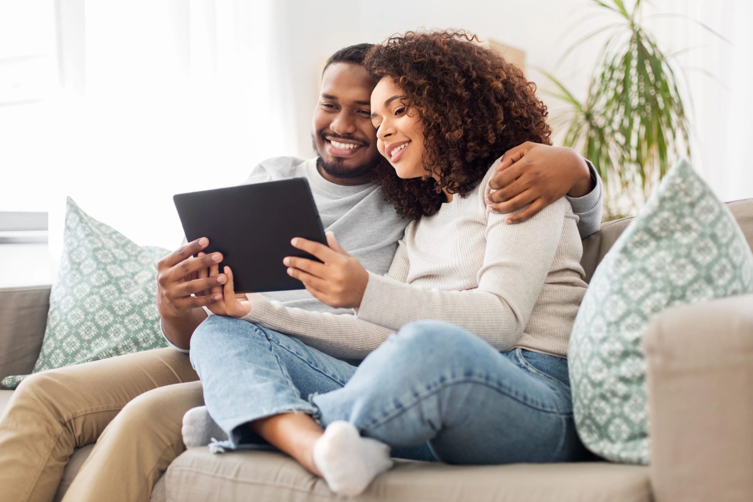 technology, internet and people concept - happy african american couple with tablet computer at home