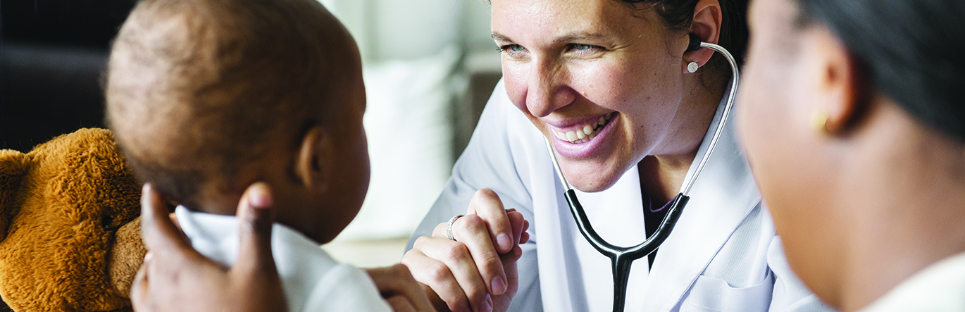 A doctor examines a baby with a stethoscope.