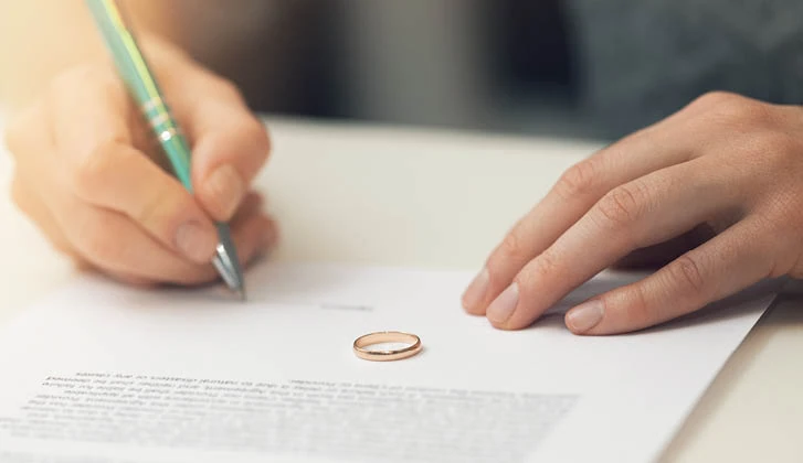 A man signs a divorce document.