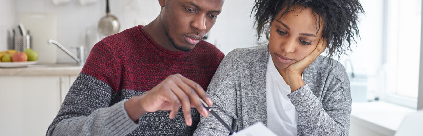 A young couple examines a document seriously.