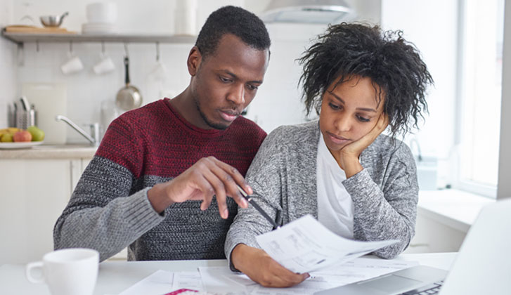 A young couple examines a document seriously.