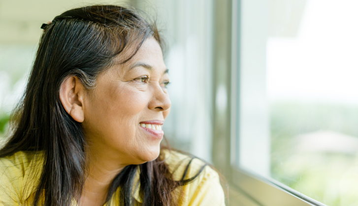 Elderly woman looking out the window