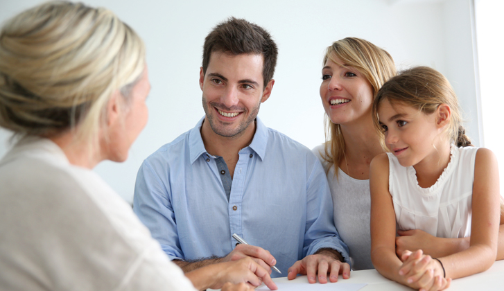 Smiling young couple with daughter get assistance from female representative.