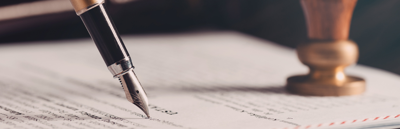 Fountain pen in the act of signing a sealed document.