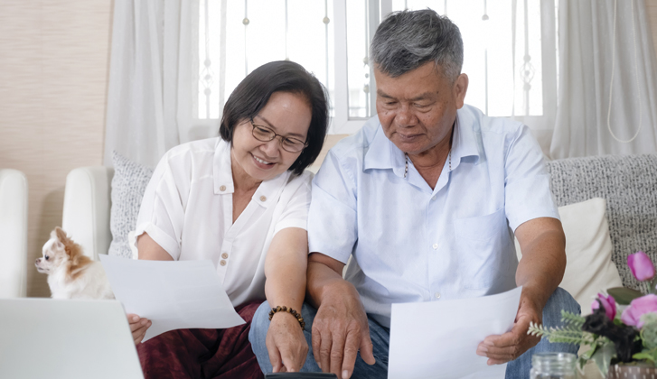Asian couple going through documents