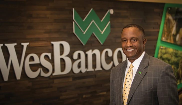 Abdul Muhammad standing in front of WesBanco logo