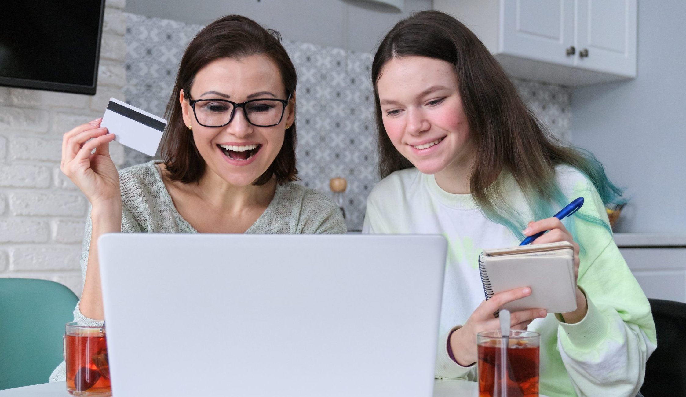 Mother and daughter using laptop credit card and doing online shopping