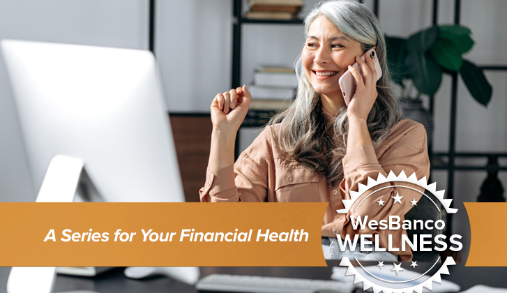 Older asian woman on cellphone at desk.