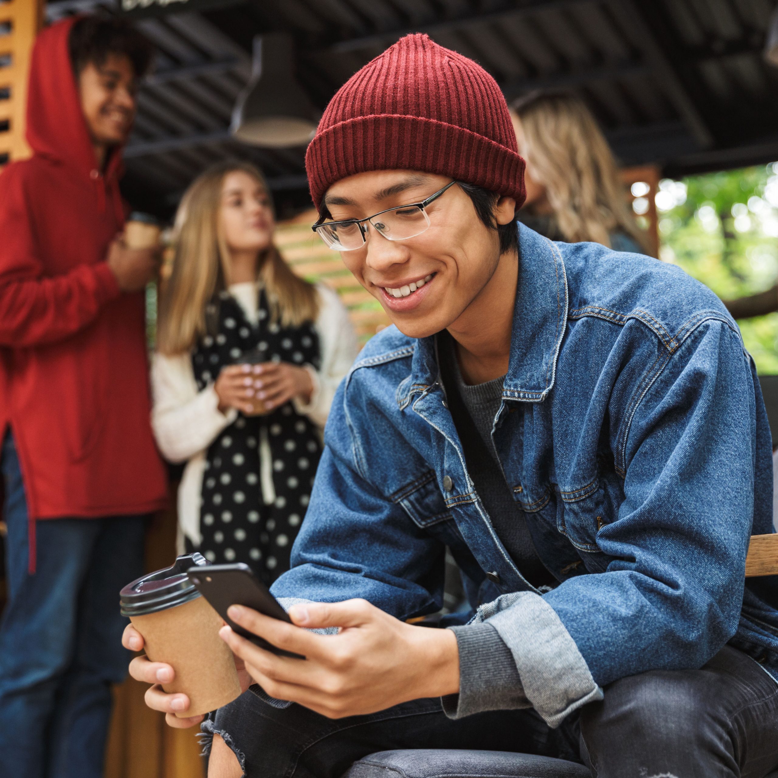 Smiling asian teenager sitting outdoors