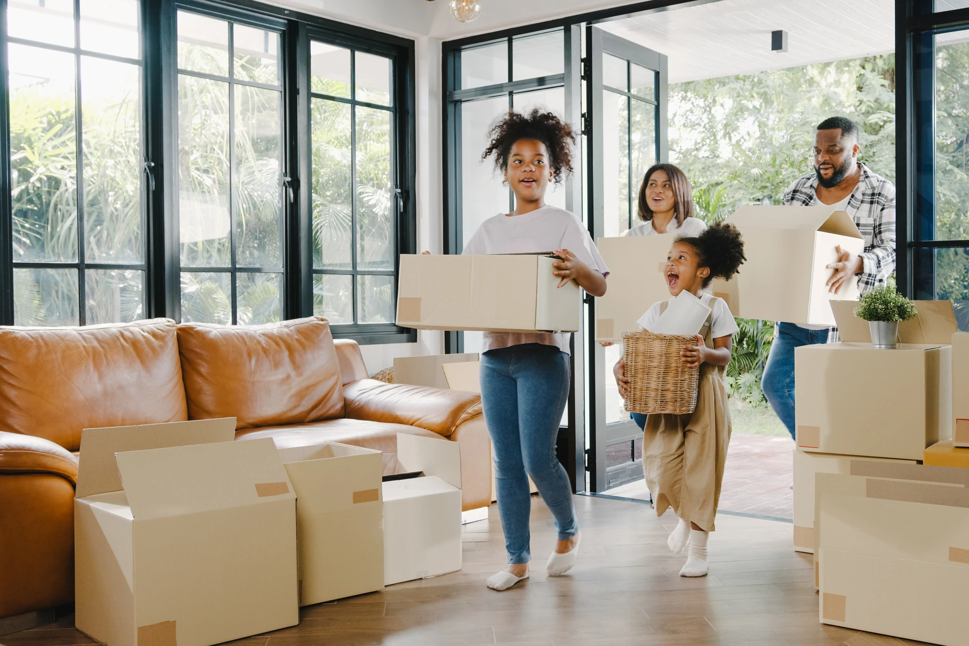 Family of four moving boxes into their new house.