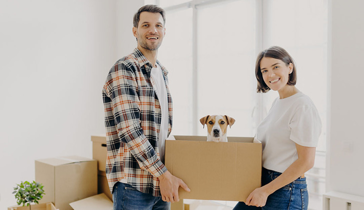 Couple holding a box with a puppy in it.