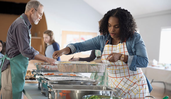 Woman preparing Food for community dinner in soup kitchen community
