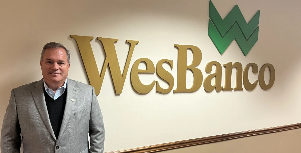 WesBanco CEO Todd Clossin standing in front of a WesBanco sign in the bank's headquarters in Wheeling, WV