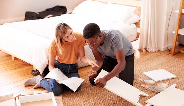Couple assembling furniture together.