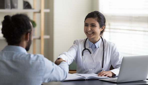 Young physician shaking hands with a patient