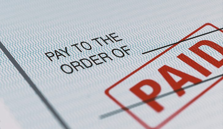 Close-up image of a financial document that says “pay to the order of” with a “paid” stamp