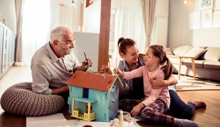 Multigenerational family playing with a dollhouse