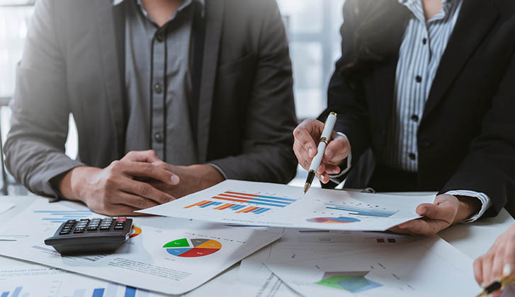 Business team collaborating and analyzing financial data while discussing strategies for company growth during a productive meeting