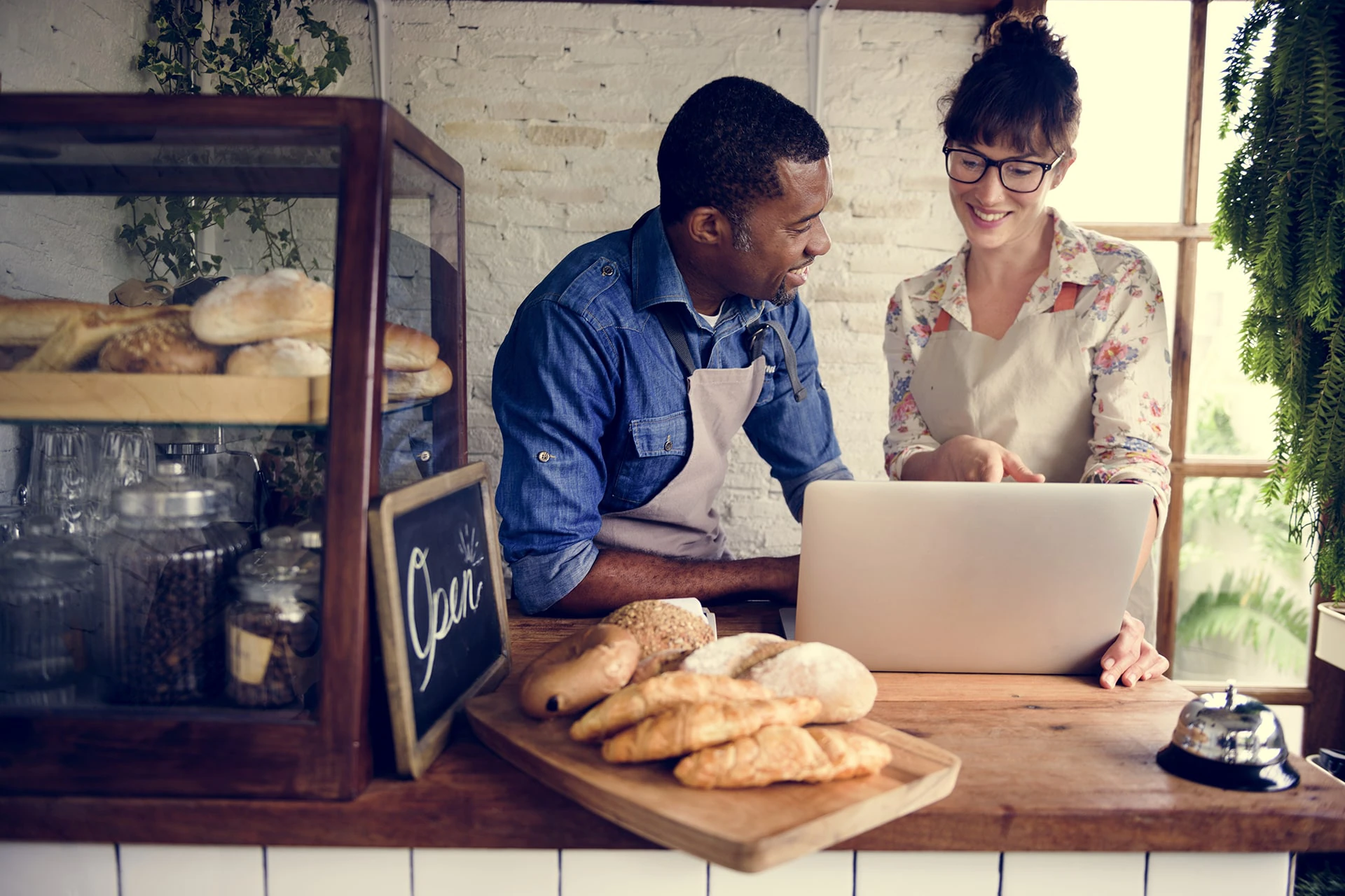 two people looking at a laptop in a kitchen